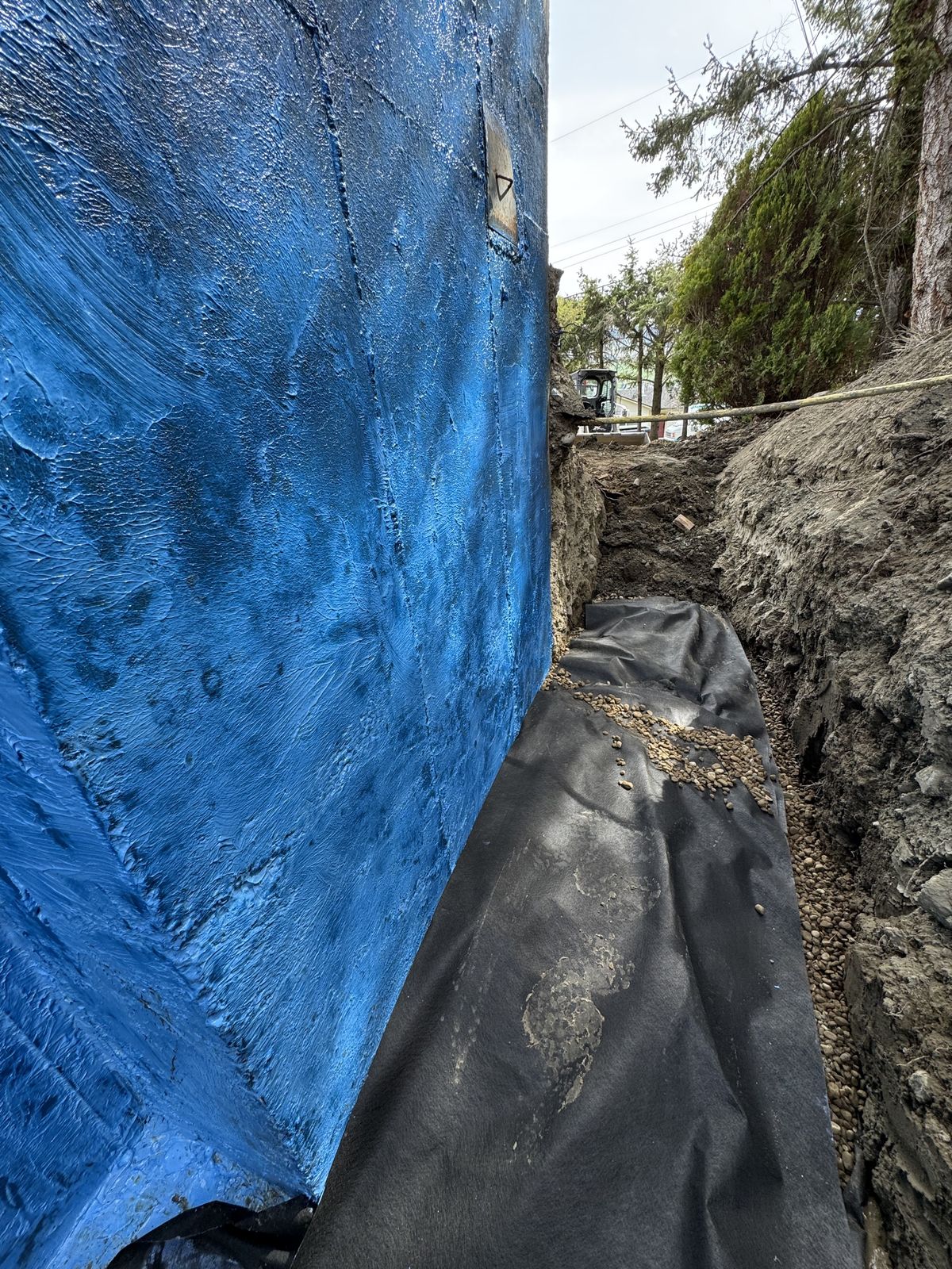 Blue waterproofing membrane on a foundation wall