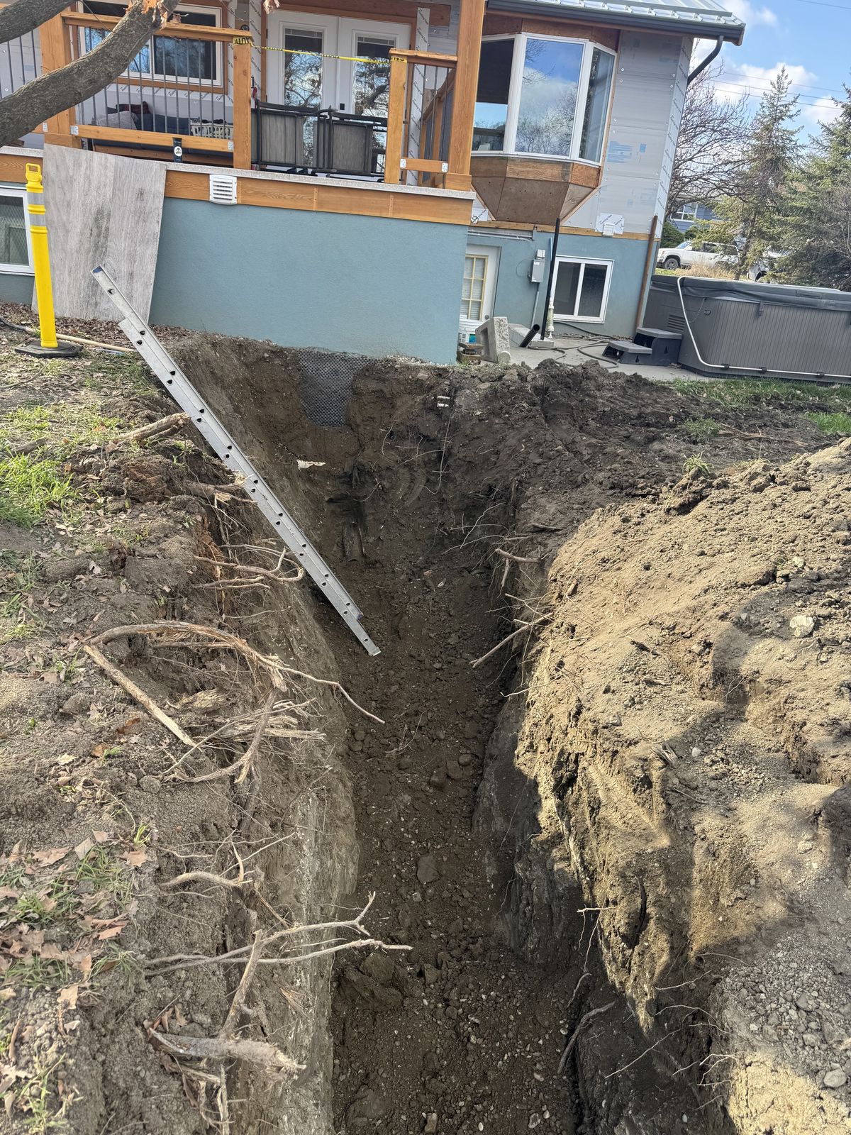 Drainage trench with pipe running along the back of a home